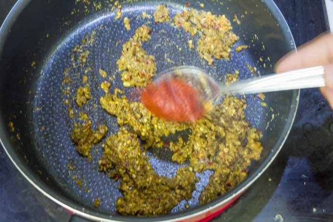 أطبخ حتى يثخن قوام الخليط ثم أضف معجون الطماطم وأطبخ حتى ينضج الثوم 